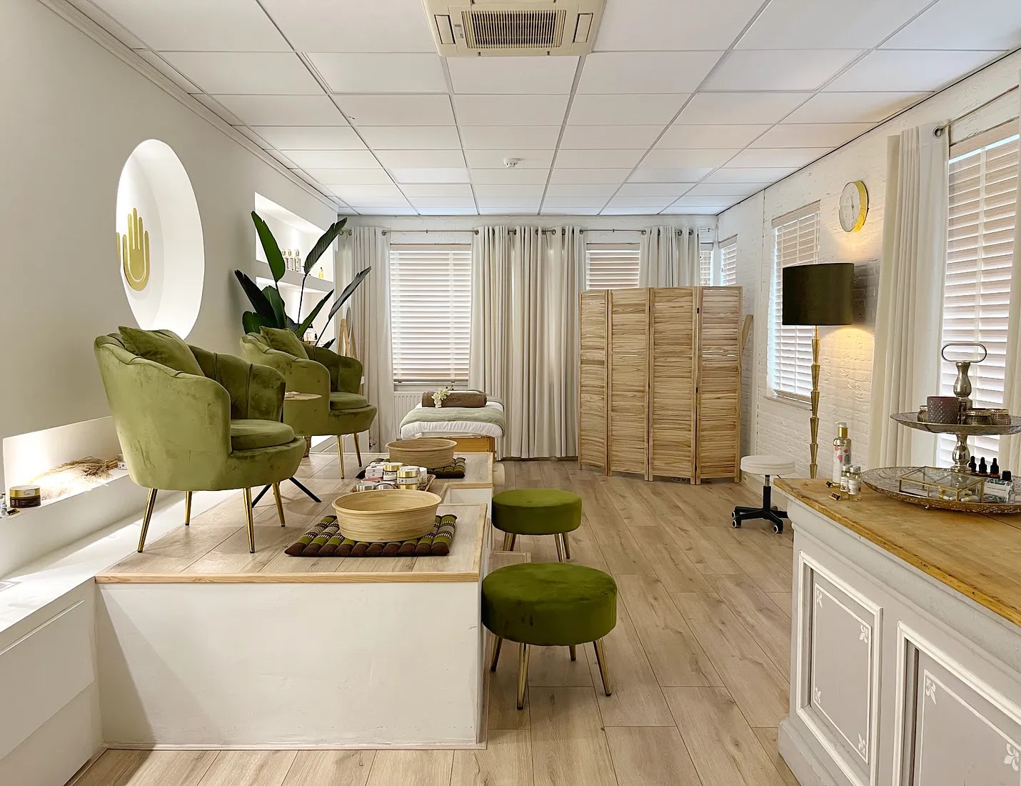 Overzicht van de salon met de ontvangstbalie, planten en het podium met de voetenbaden