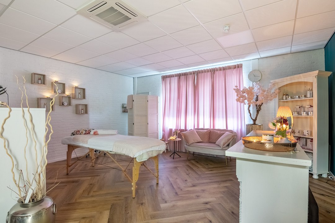 De behandelruimte Classic met massagetafel en roze gordijnen