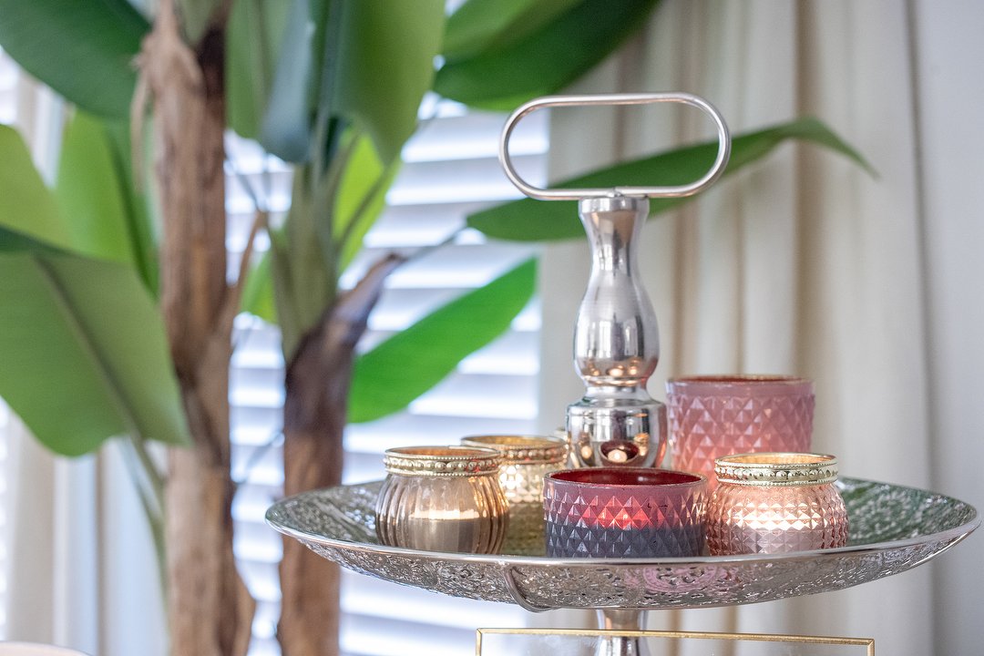 Een etagère met waxinelichtjes tussen de planten