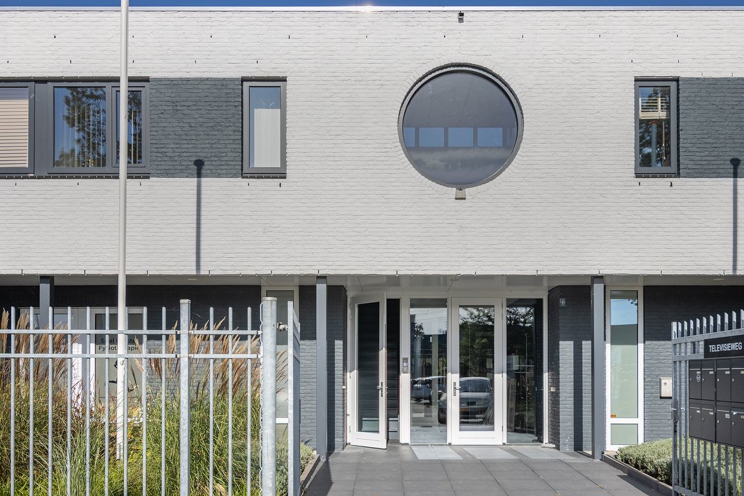 Het bedrijfsgebouw aan de Televisieweg met het ronde raam boven de ingang