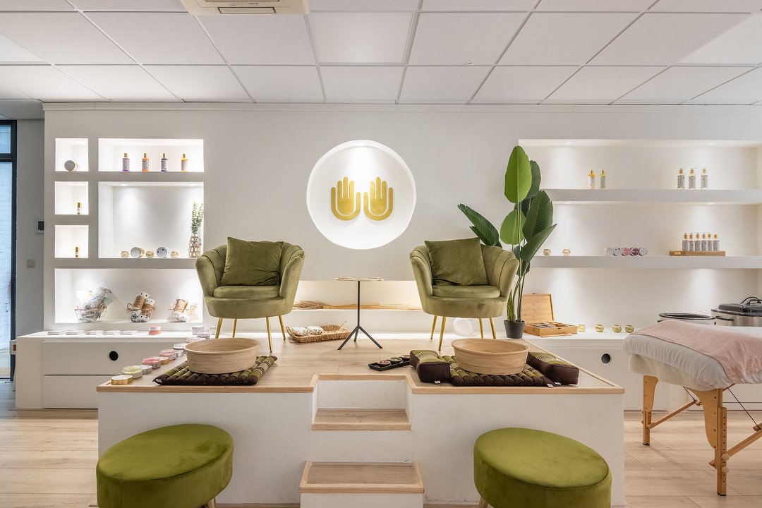 De behandelruimte Nature: twee groene fluwelen stoelen bij de voetenbaden, met de gouden handen aan de muur